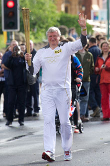 Professor Neil Gorman carrying the Olympic flame