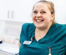 A smiling female vet nurse