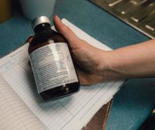 A hand holding a bottle of animal medicine