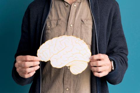 Picture of a man holding a cardboard cutout of a brain 