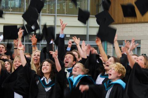 Graduates throwing caps in air